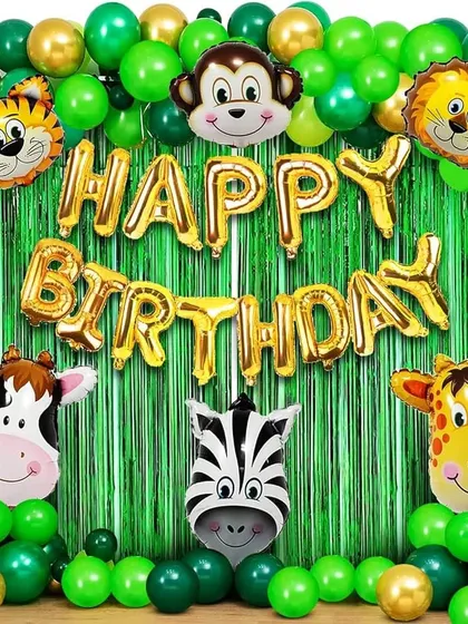 A simple jungle animal theme for a birthday party. This setup features a green fringe backdrop, "Happy Birthday" foil balloons, and various animal-shaped foil balloons.