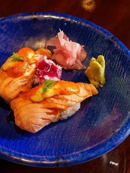 A feast for your senses. This plate of torched salmon nigiri is a work of art, with bold flavors and a beautiful presentation that promises culinary perfection.