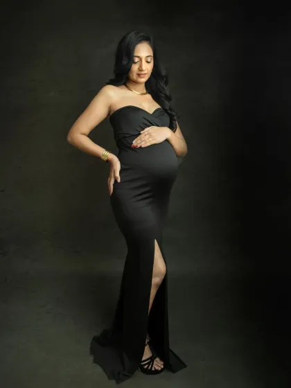 A full-length solo portrait in a classic black gown. This pose is all about showcasing your confidence and the beautiful curves of pregnancy.