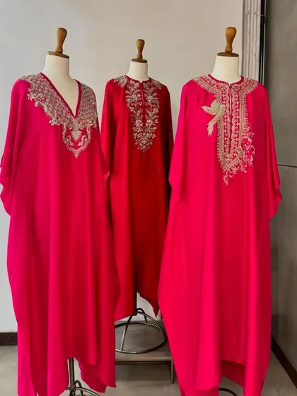 Another view of the red and pink kaftans, showcasing their flowing silhouettes and glamorous appeal.