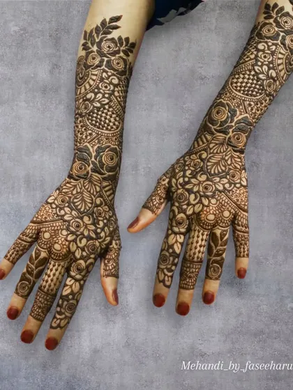 A crisp, high-contrast photo of a full Indian henna design, combining bold florals with delicate, traditional patterns.
