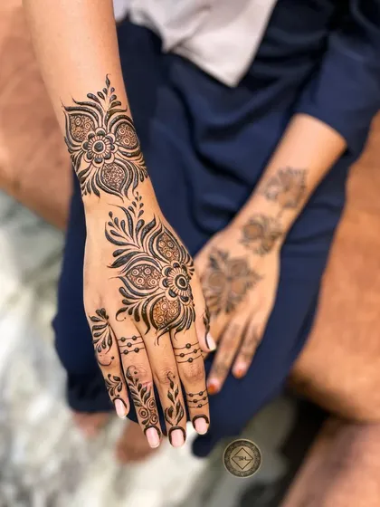 This is a classic Arabic henna style, known for its bold floral and vine patterns that flow beautifully across the hand. It's an elegant choice that is perfect for wedding guests and parties.