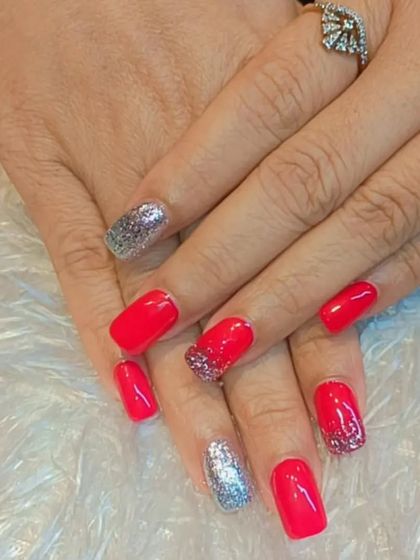 A festive and fun manicure combining bright red nails with full-coverage silver glitter accent nails. This classic color combination is perfect for holidays and celebrations.