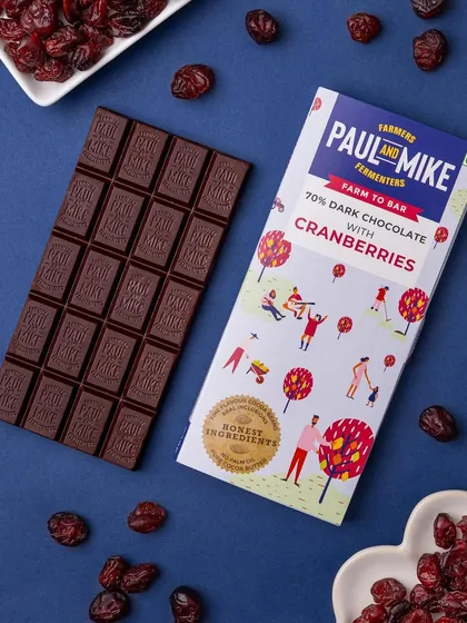 This 70% dark chocolate with cranberries is styled with scattered cranberries against a dark background. This creates a rich, moody image that highlights the key ingredient.