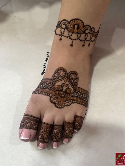 A chic and simple foot design with a peacock band across the top of the foot and a matching delicate anklet design.