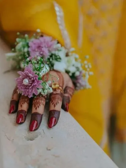 A close-up of the beautiful dark stain on the fingertips, complemented by a delicate floral hand accessory. This is the rich color my natural henna produces.
