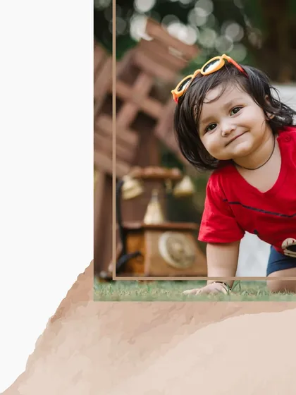 An artistic crop of a toddler's happy, curious face. This close-up captures his charming expression and playful energy during an outdoor session.