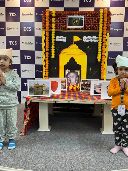 Two little girls in front of our Gurpurab setup. We encourage children to dress for the occasion to feel more connected to the celebration.