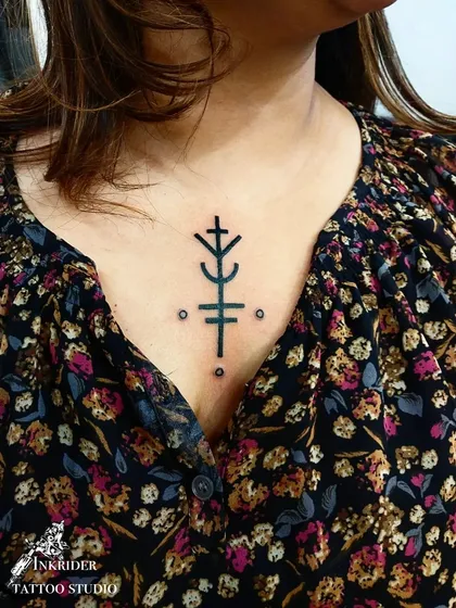 This sigil tattoo on the chest is a custom symbol of luck. We work with clients to create unique sigils that represent their personal intentions and desires.