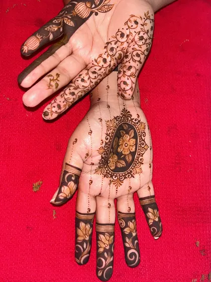 Another angle of the asymmetrical bridal design, focusing on the hand with the central medallion and detailed finger work. This is a great option for brides who want something non-traditional.