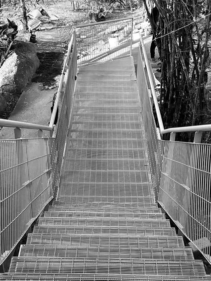 Angles that break the norm. This black and white shot of a metal staircase descending into a ravine highlights our use of strong, functional geometry.