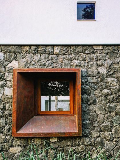 A deeply recessed, copper-clad window punches through a traditional stone wall. This juxtaposition of modern and traditional materials highlights our approach of respectfully adding new layers to existing contexts.