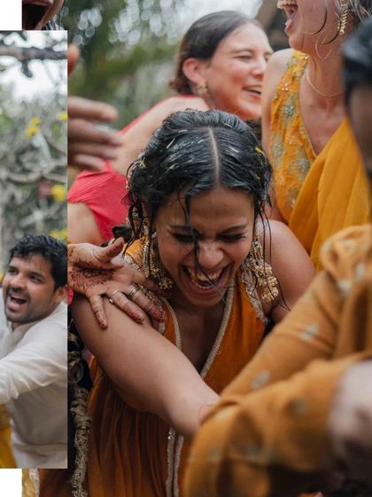 A candid shot of the bride laughing uncontrollably as she's surrounded by friends and family during her Haldi.