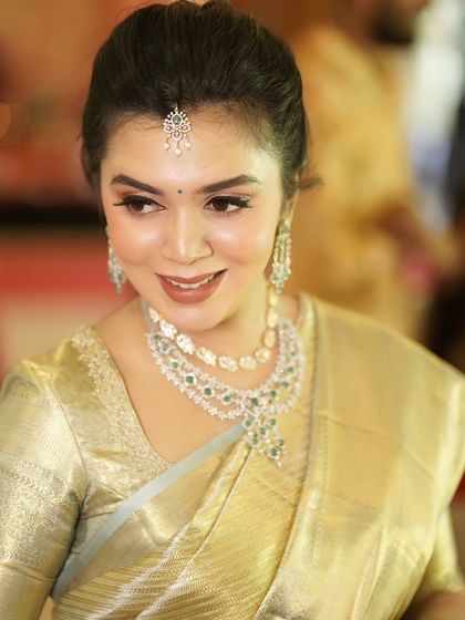 The gorgeous mom-to-be, Monica, looking serene and beautiful. Her makeup is soft and glowing, highlighting her features and complementing her traditional attire.