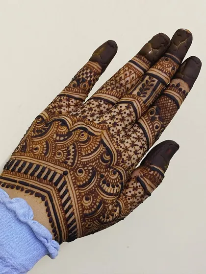 A geometric design on the back of the hand, featuring clean lines and intricate fillers. A modern and chic choice.