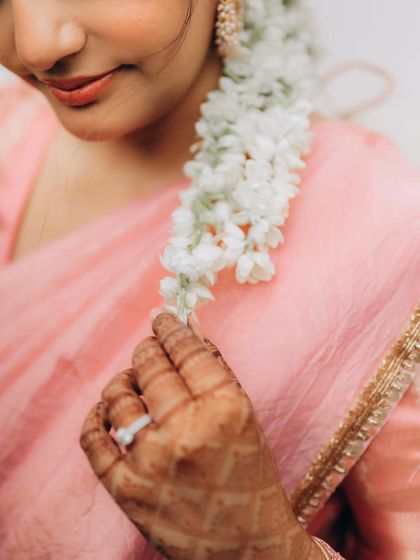 A delicate shot of the bride's hand with her engagement ring, gently touching the gajra in her hair. It’s these small, poetic details that I love to freeze in time.