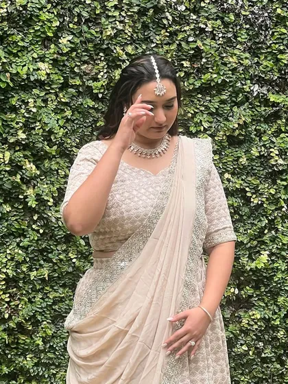 Mehendi magic for this stunning bride. She is wearing a beautiful cream-colored lehenga, and her makeup is soft and ethereal.