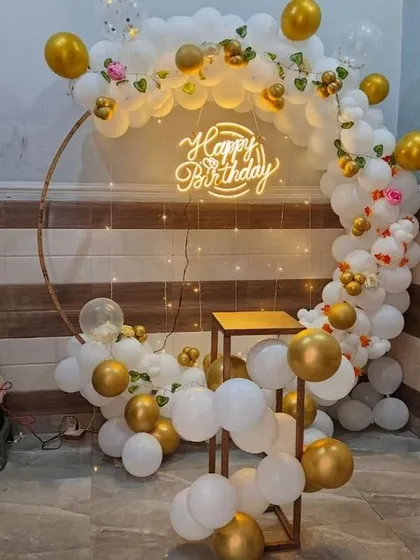 A simple and elegant white and gold balloon ring. This compact setup is ideal for smaller spaces, providing a beautiful backdrop for cake cutting and photos.