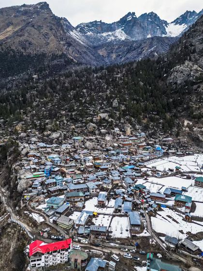 A top-down drone photograph of a village nestled in the Kinnaur valley, surrounded by snow and towering peaks. This perspective reveals the patterns of life at high altitudes.