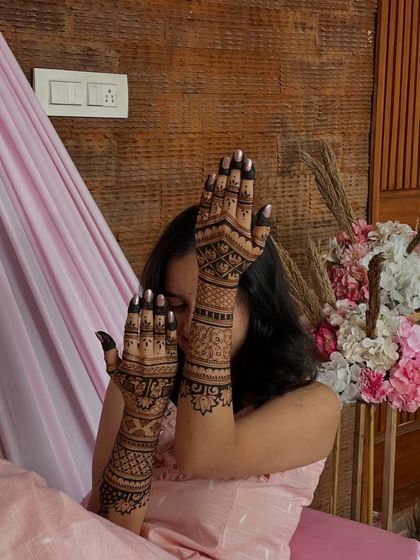 A classic peek-a-boo pose with Rakshitha, highlighting the beautiful details of her bridal henna.