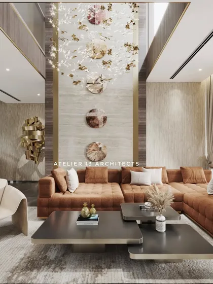 Inside one of our farmhouse projects, this double-height living space is designed for both grand entertaining and intimate family life. The room features a custom tan L-shaped sofa, elegant Italian chairs, and a striking wall clad in beige marble, all illuminated by a bespoke crystal chandelier.