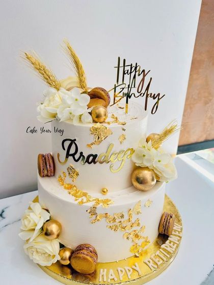 A celebration of gold and elegance. A two-tier cake for a combined birthday and retirement party.
