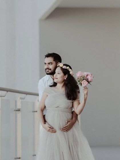 A beautiful maternity portrait where the mom-to-be is holding a bouquet of flowers. It adds a soft, romantic touch to the image.