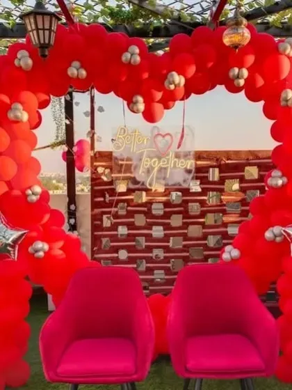 A 'Better Together' terrace setup with a heart-shaped red balloon arch, perfect for a romantic date or anniversary.