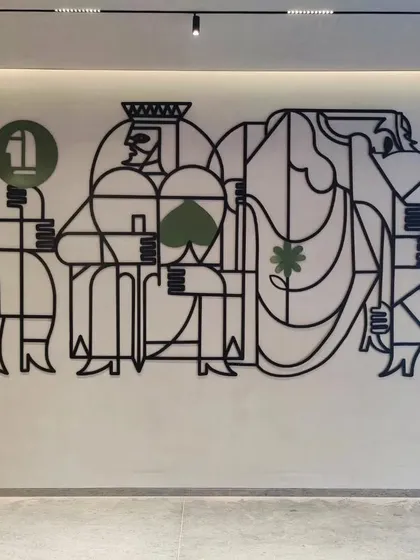 Another view of the card-themed metal installation, showing its scale and clean, modern aesthetic.