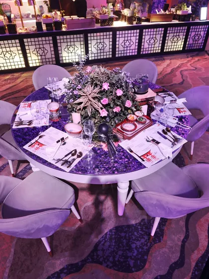 An intimate table setting with a stunning floral centerpiece and custom "Curry Nama" place settings, showcasing our attention to personalized detail.