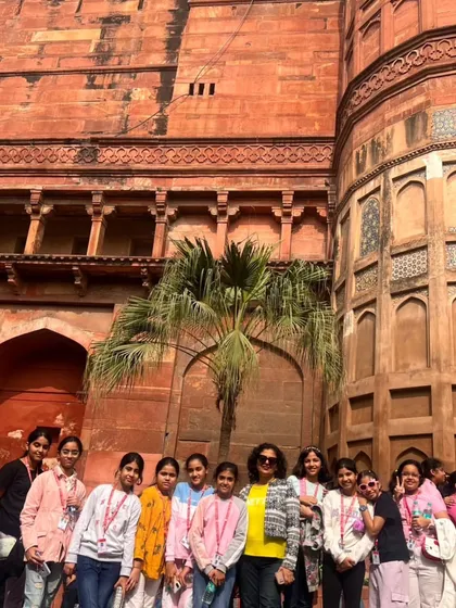 Students and teachers pose in front of the historic Agra Fort. Our educational trips offer deep insights into Mughal architecture and India's rich history.