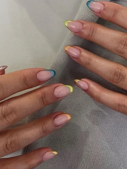 A subtle yet colorful take on the French manicure. Each nail features a different pastel-colored tip, creating a playful and minimalist rainbow effect.