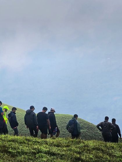A group of trekkers making their way down a slope on the Bandaje trail.