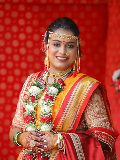 A classic bridal portrait. Her makeup is elegant and timeless, enhancing her natural beauty and complementing her traditional Maharashtrian attire.
