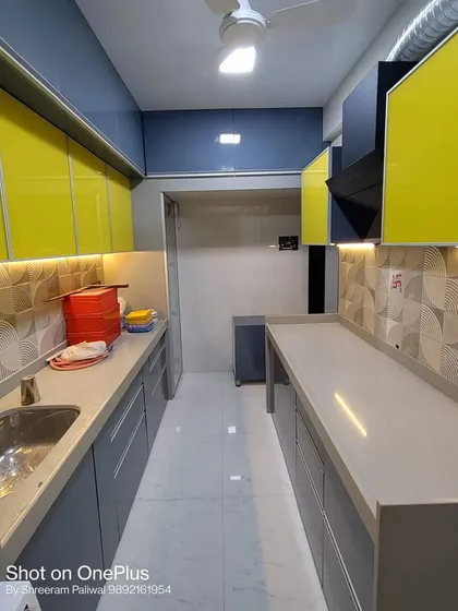 Another angle of the yellow and grey kitchen, showing the parallel counter setup. This layout provides an efficient work triangle and plenty of counter space for a busy household.