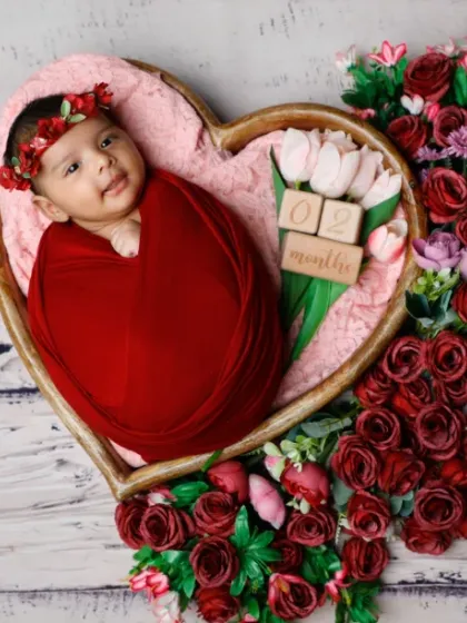 A heart full of roses. This awake shot captures a beautiful, happy expression from a baby nestled in a heart-shaped floral arrangement.