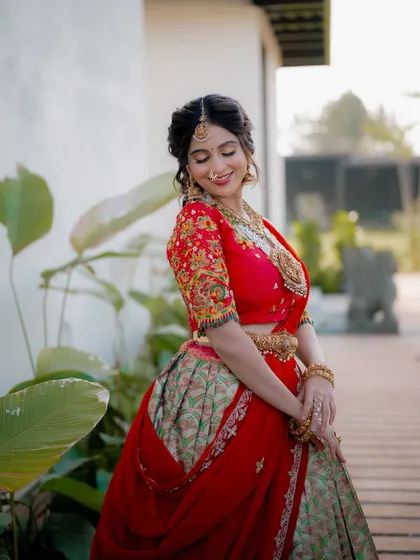 A candid shot of actress Niveditha Gowda in a beautiful half saree. Her natural movement and smile bring a sense of life and joy to the portrait.