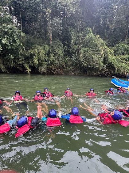A team-building exercise in the Barapole river, where participants form a floating circle. This activity fosters trust and communication among campers.
