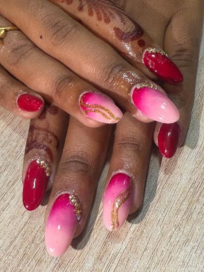 A close-up of the ombre nail set, highlighting the glitter detail at the cuticle on the solid red nails.