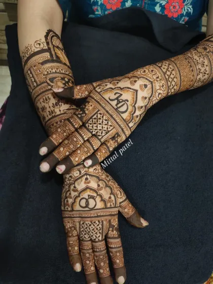 A full view of the engagement design, showcasing the personalized initials, rings, and intricate patterns popular up to the elbows.