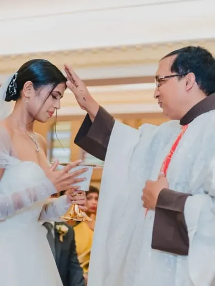 The priest giving his blessing to the bride during a solemn moment in the Catholic wedding mass.