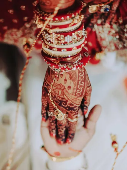 The moment it all becomes real. A close-up of the bride's hand, rich with the color of my natural henna, resting in the groom's hand during the wedding ceremony.