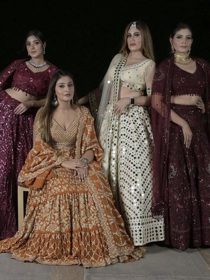 Another group shot of our glitter and glimmer lehengas. The combination of the ivory mirror-work lehenga with the rich wine and rust tones creates a beautiful and cohesive wedding party look.