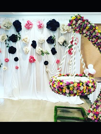 The paper flower wall and hanging cradle decoration in bright, natural light, showing the true colors of the floral arrangement.