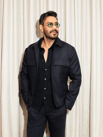 Another angle of the premiere look, showing the texture of the jacket and the sleek pinstripe trousers.