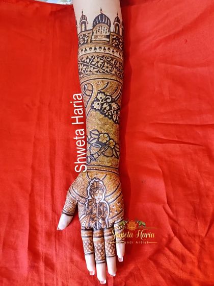 A detailed shot of one arm, highlighting the bride portrait and the various bands of patterns, including floral, geometric, and architectural elements.