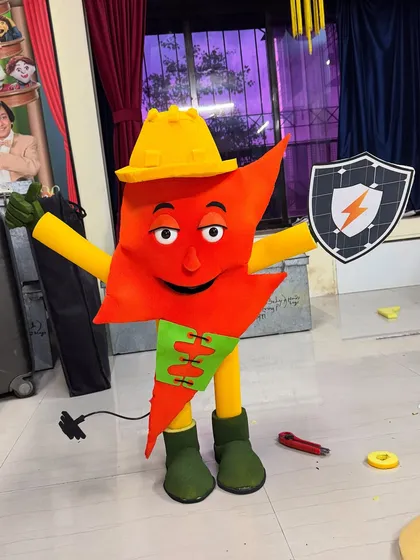 A full-length view of the finished Suraksha Shakti puppet in my studio. The design incorporates elements of electricity and safety, like the hard hat and shield.