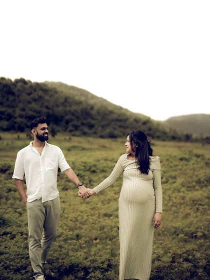 A full-length shot of the couple walking hand-in-hand through a lush green field, showcasing their journey together in a beautiful, natural setting.