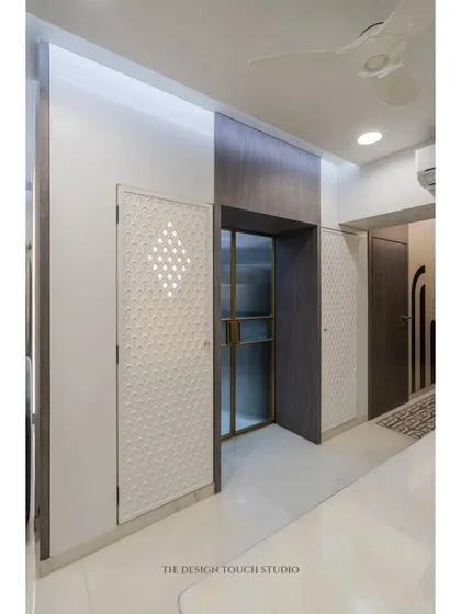 This compact mandir is cleverly integrated into the home's passageway. The custom-designed Corian door with its geometric cutouts offers a glimpse of the sacred space inside.