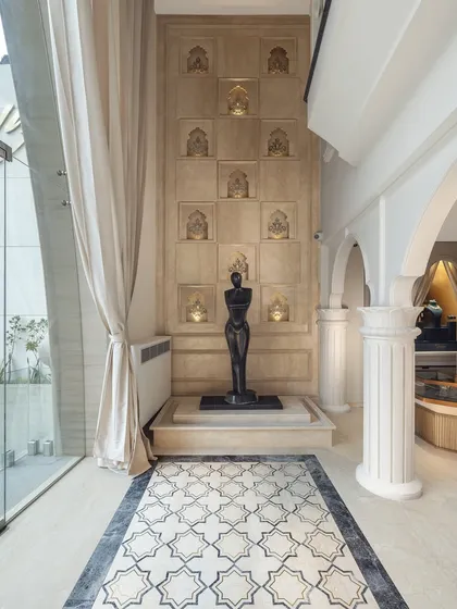 The full view shows the sculpture as a central feature in the store's design. It is framed by classical columns and an intricate marble floor inlay, creating a moment of artistic pause for customers.